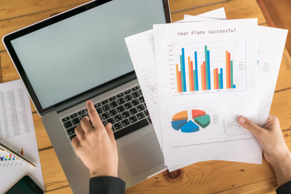 Business woman hand with Financial charts and laptop on the tabl