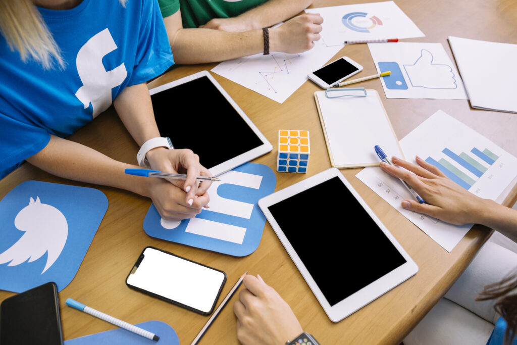 close-up-businesspeople-with-digital-tablet-social-media-icons-table